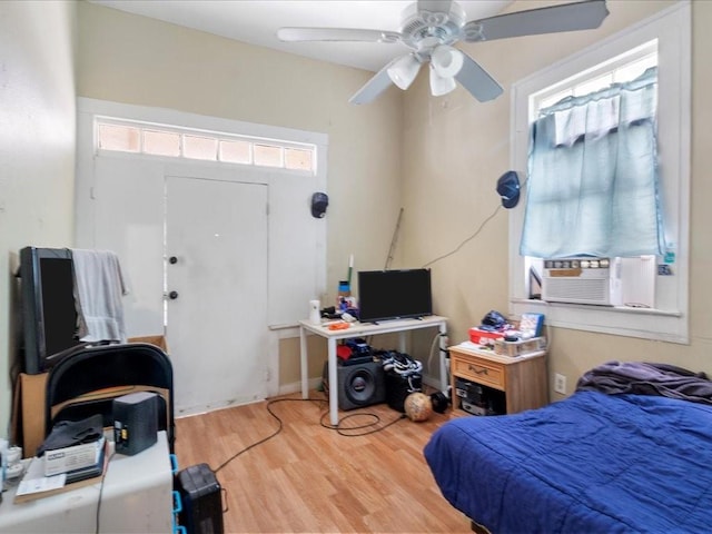 bedroom featuring ceiling fan, cooling unit, and wood finished floors