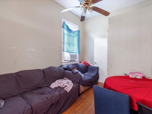 bedroom featuring light wood finished floors, cooling unit, and a ceiling fan