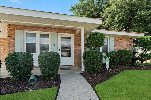 doorway to property with brick siding