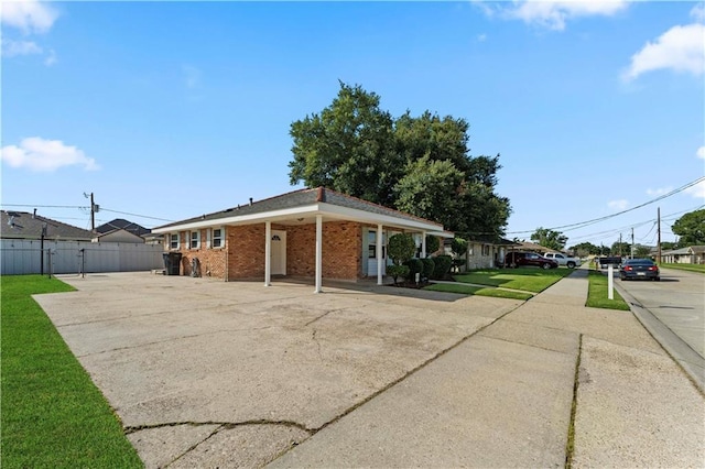 view of property exterior with a yard, brick siding, and fence