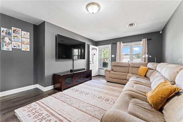 living area featuring baseboards, visible vents, and dark wood-style flooring