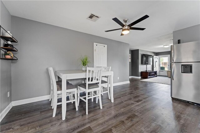 dining room with a ceiling fan, baseboards, visible vents, and wood finished floors