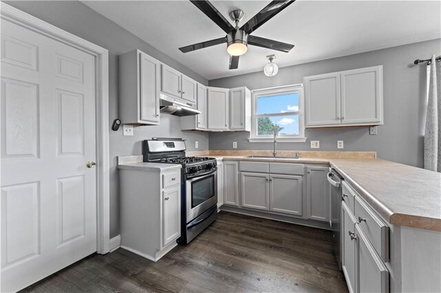 kitchen featuring stainless steel appliances, light countertops, a sink, a peninsula, and under cabinet range hood