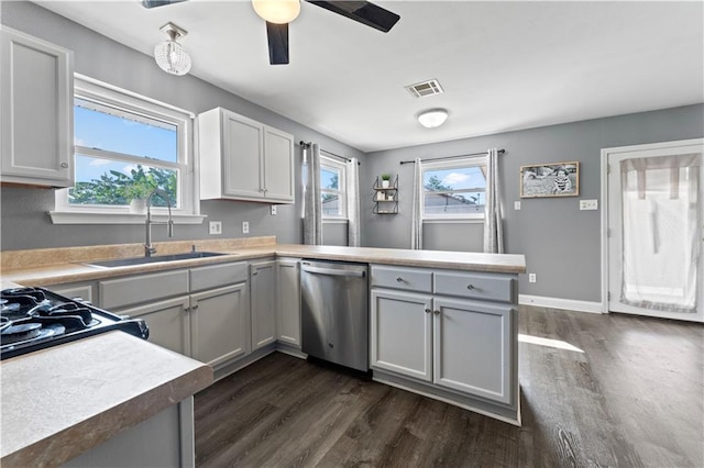 kitchen with a peninsula, dark wood-type flooring, a sink, visible vents, and stainless steel dishwasher