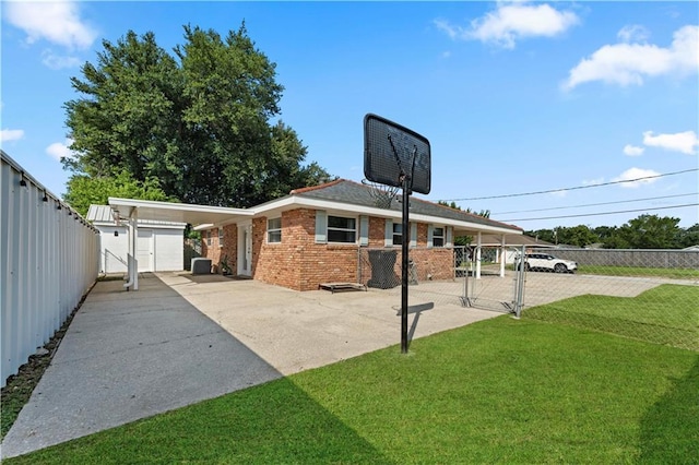 rear view of property with an attached carport, brick siding, fence, a yard, and a gate