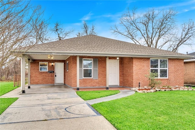 ranch-style home featuring a front lawn, a shingled roof, and brick siding