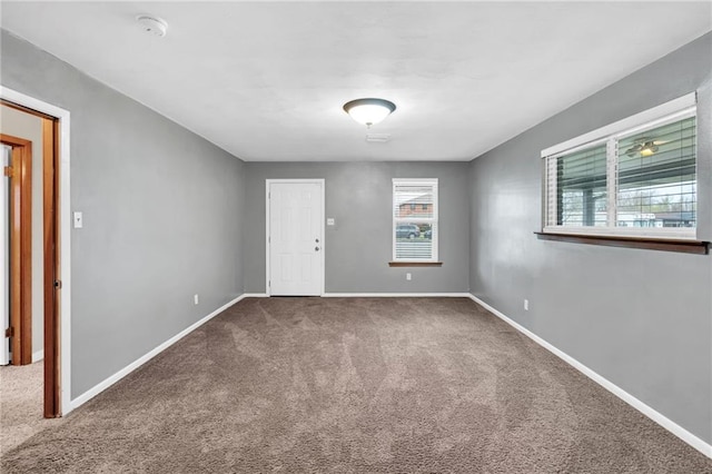 carpeted spare room featuring baseboards