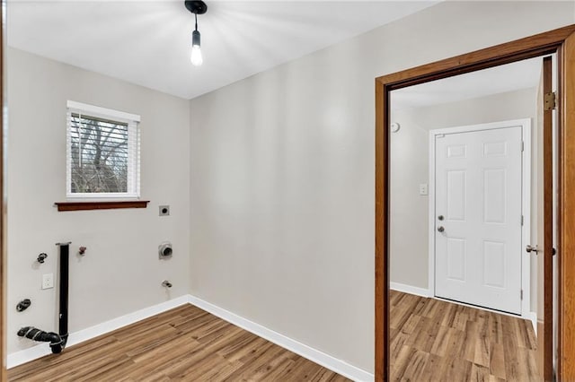 washroom featuring hookup for a gas dryer, light wood-style flooring, electric dryer hookup, laundry area, and baseboards