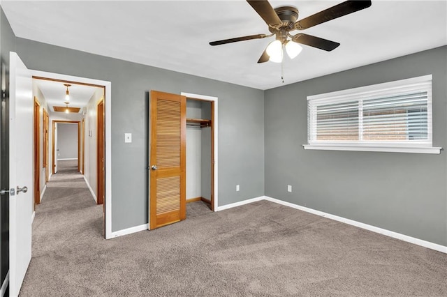 unfurnished bedroom with a ceiling fan, a closet, baseboards, and carpet flooring