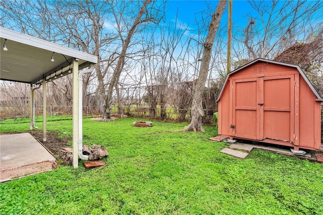 view of yard with a fire pit, a fenced backyard, a shed, and an outdoor structure