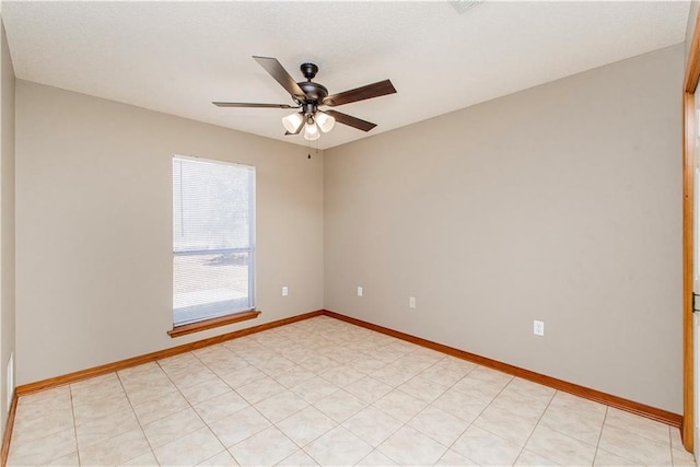 unfurnished room featuring ceiling fan and baseboards