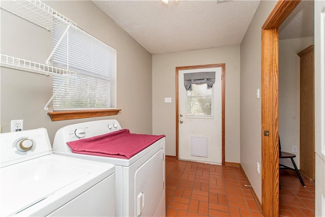 laundry room featuring brick floor, laundry area, a textured ceiling, and separate washer and dryer