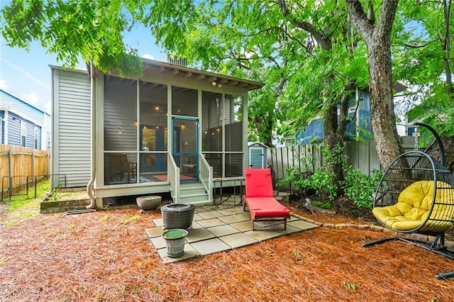 back of property featuring a sunroom, a fenced backyard, and a patio