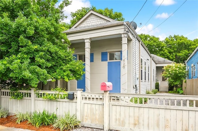 shotgun-style home featuring a fenced front yard