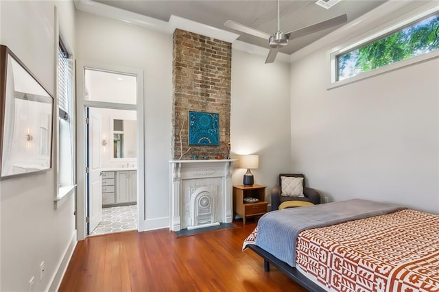 bedroom featuring ensuite bath, baseboards, and wood finished floors