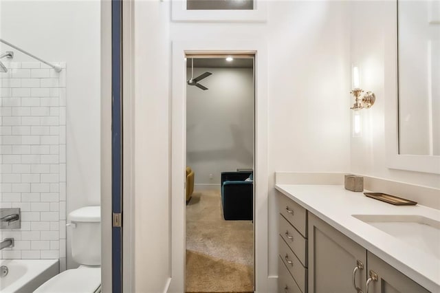 bathroom with tub / shower combination, vanity, and toilet