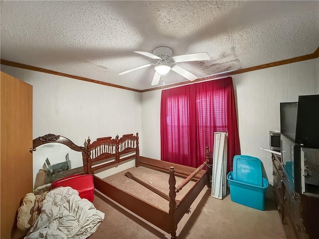 bedroom featuring a ceiling fan, a textured ceiling, ornamental molding, and carpet flooring