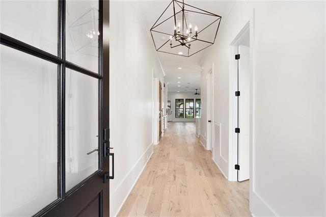 corridor featuring light wood-type flooring and baseboards