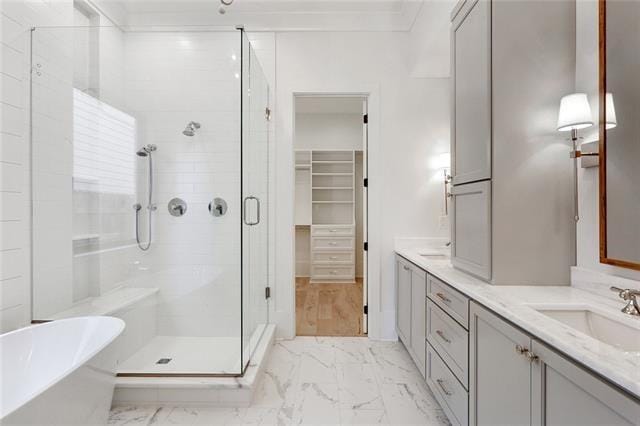 bathroom featuring a stall shower, marble finish floor, and a sink