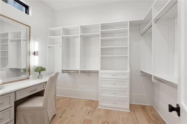 spacious closet featuring light wood-type flooring and built in desk