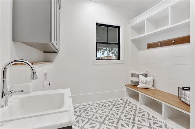 mudroom featuring baseboards and a sink