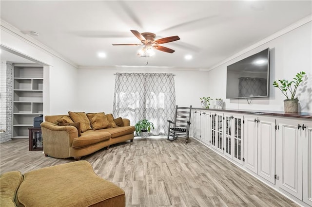 living area with ornamental molding, built in features, and light wood finished floors