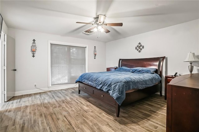 bedroom with ceiling fan, wood finished floors, and baseboards