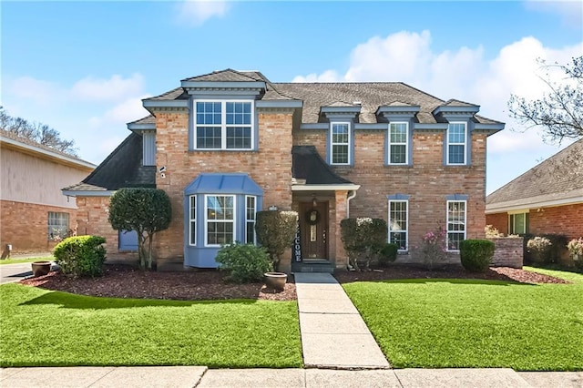 view of front of house with a front yard and brick siding