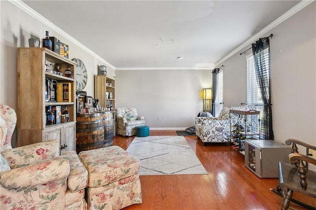 living area featuring baseboards, ornamental molding, and hardwood / wood-style floors