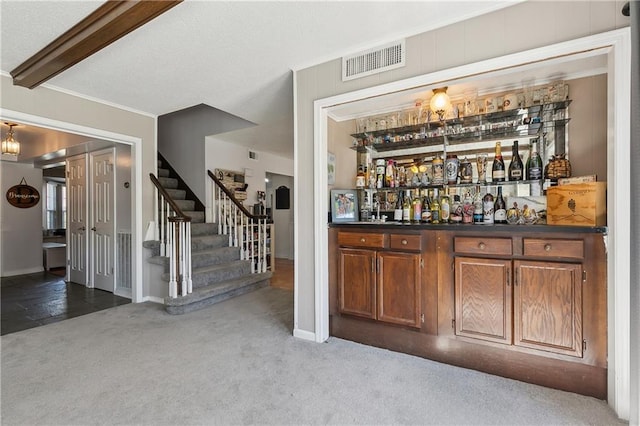 bar featuring visible vents, ornamental molding, carpet, stairs, and a bar