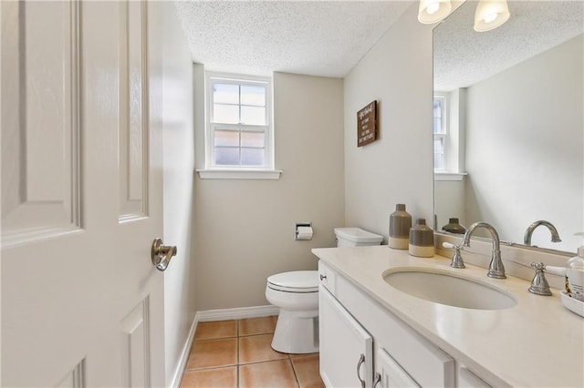 bathroom featuring toilet, vanity, a textured ceiling, baseboards, and tile patterned floors