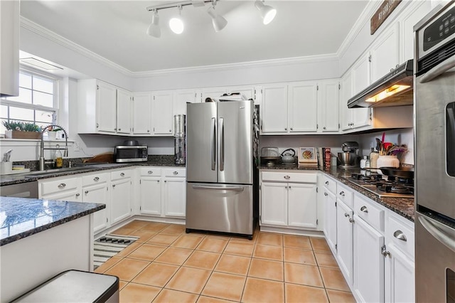 kitchen with under cabinet range hood, light tile patterned floors, appliances with stainless steel finishes, and crown molding