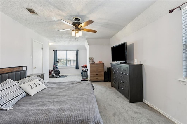 bedroom with visible vents, light carpet, ceiling fan, a textured ceiling, and baseboards