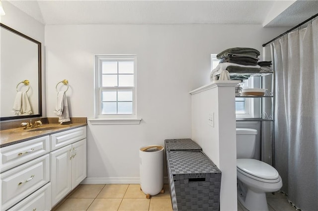 bathroom with toilet, vanity, baseboards, and tile patterned floors