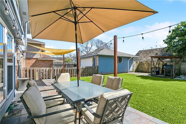 view of patio with a fenced backyard, an outdoor structure, and outdoor dining space