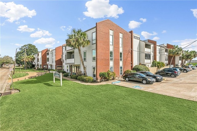 view of building exterior with uncovered parking and a residential view