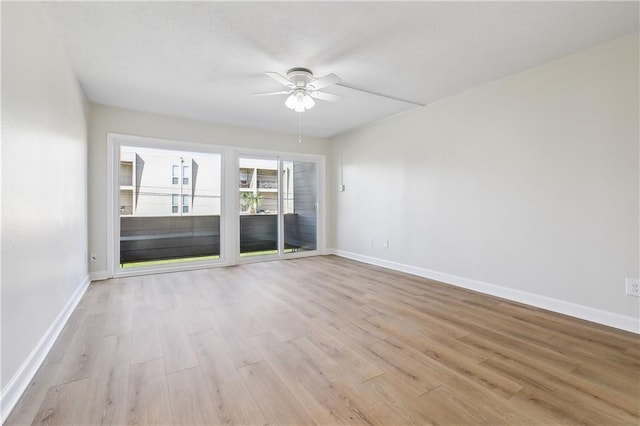 unfurnished room with baseboards, light wood-style flooring, and a ceiling fan