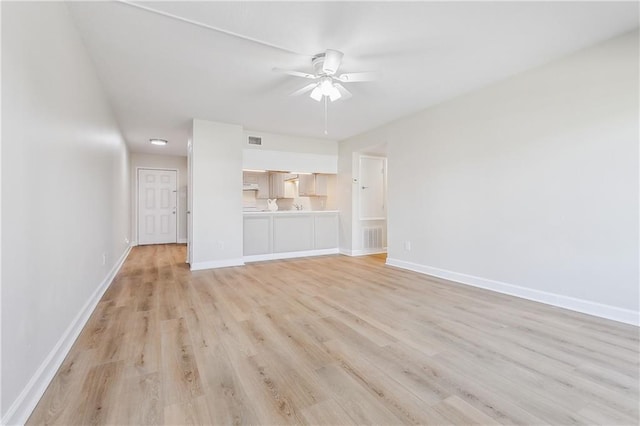 unfurnished living room with light wood-style flooring, visible vents, baseboards, and a ceiling fan