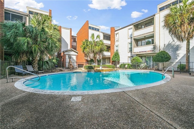 pool featuring fence and a patio