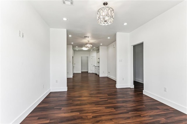 spare room featuring recessed lighting, a notable chandelier, dark wood-style flooring, visible vents, and baseboards