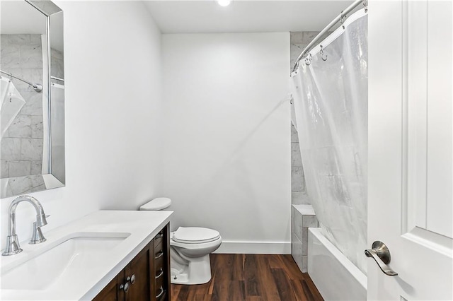 bathroom featuring shower / tub combo, baseboards, toilet, wood finished floors, and vanity