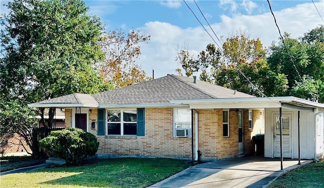 ranch-style home with an attached carport, driveway, roof with shingles, a front lawn, and brick siding