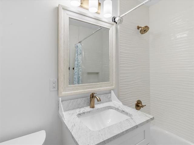 bathroom featuring toilet, shower / bath combination with curtain, and vanity