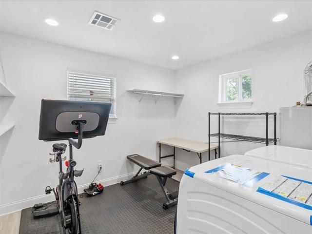 exercise room featuring washer and clothes dryer, recessed lighting, visible vents, and baseboards