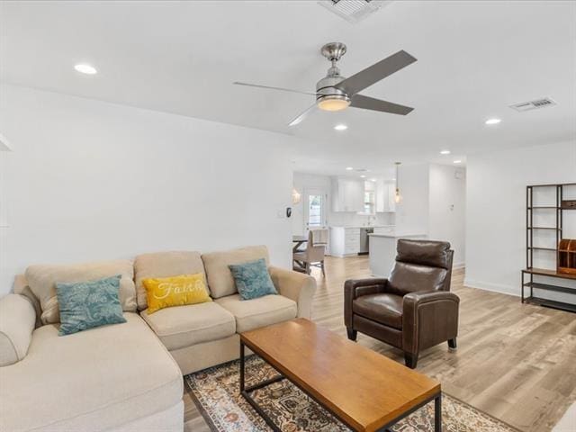 living room with ceiling fan, recessed lighting, visible vents, and light wood-style floors