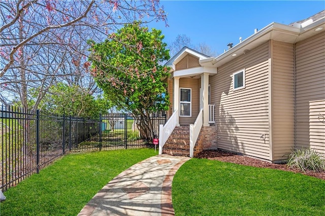 view of exterior entry with a yard and fence