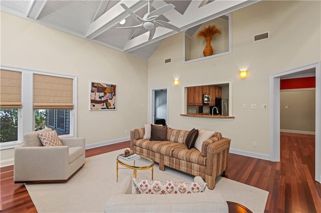 living room featuring baseboards, visible vents, ceiling fan, dark wood-type flooring, and beamed ceiling