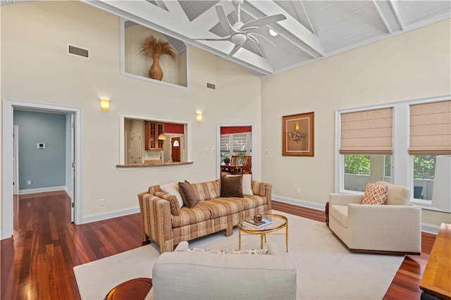 living room featuring baseboards, visible vents, ceiling fan, wood finished floors, and beamed ceiling