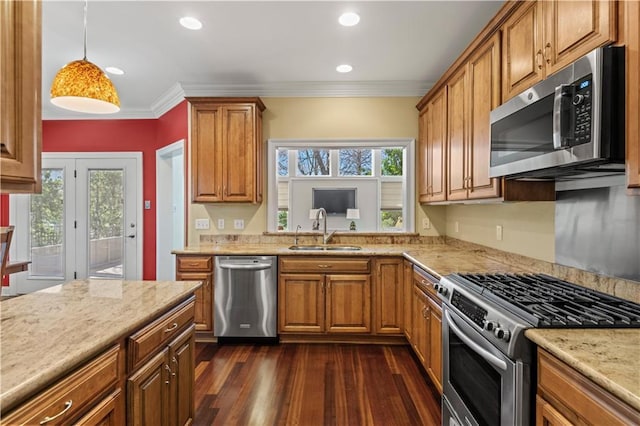 kitchen with stainless steel appliances, ornamental molding, brown cabinetry, and a sink