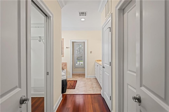 hall with ornamental molding, recessed lighting, visible vents, and baseboards